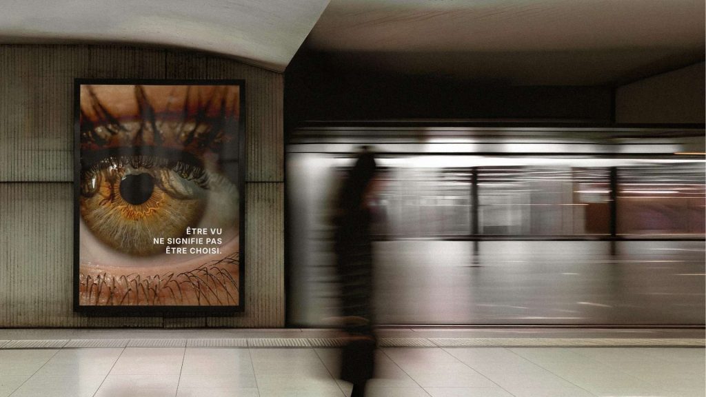 Panneau d'affichage publicitaire urbain dans une station de métro avec un gros plan sur un œil humain et le texte engagé « Être vu ne signifie pas être choisi », illustrant l'importance de la constance de marque et de l'impact publicitaire.